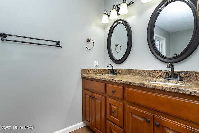 bathroom featuring double vanity, tile patterned flooring, baseboards, and a sink