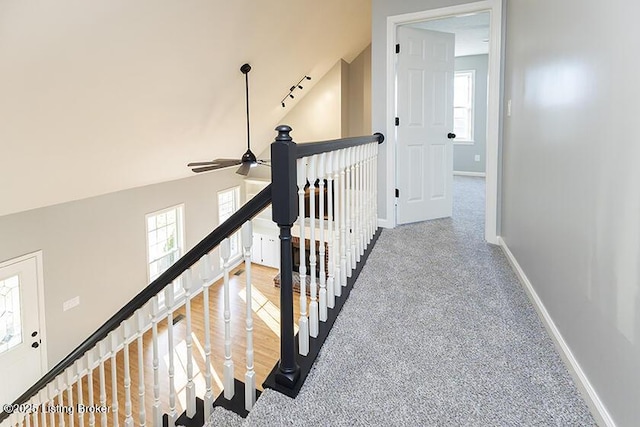 interior space with baseboards, an upstairs landing, carpet, and high vaulted ceiling