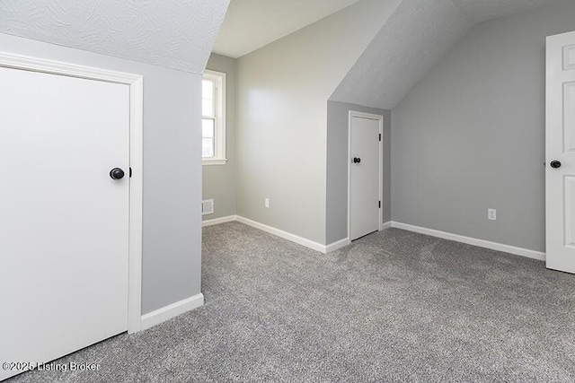 bonus room featuring visible vents, baseboards, vaulted ceiling, carpet flooring, and a textured ceiling