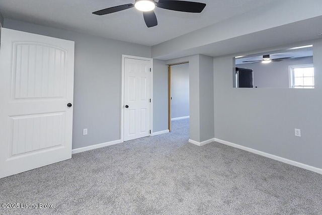 interior space with a ceiling fan, baseboards, and carpet floors