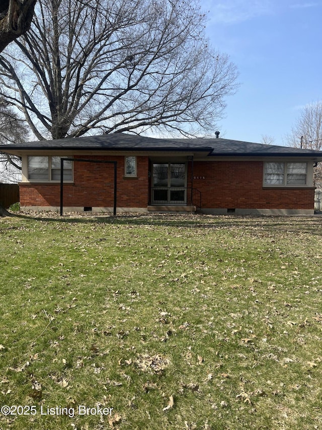 back of property featuring a yard, brick siding, and crawl space