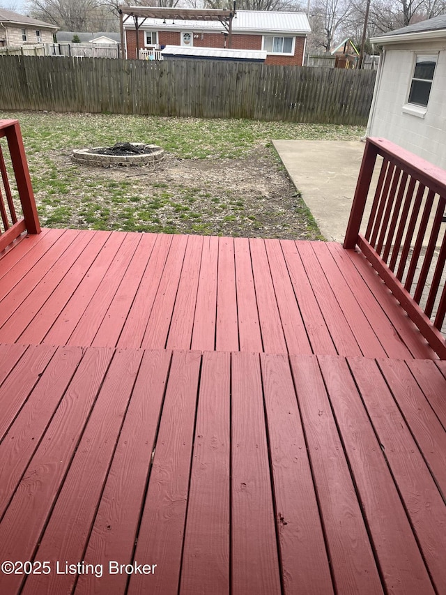 wooden deck with a fire pit, a fenced backyard, and a patio area