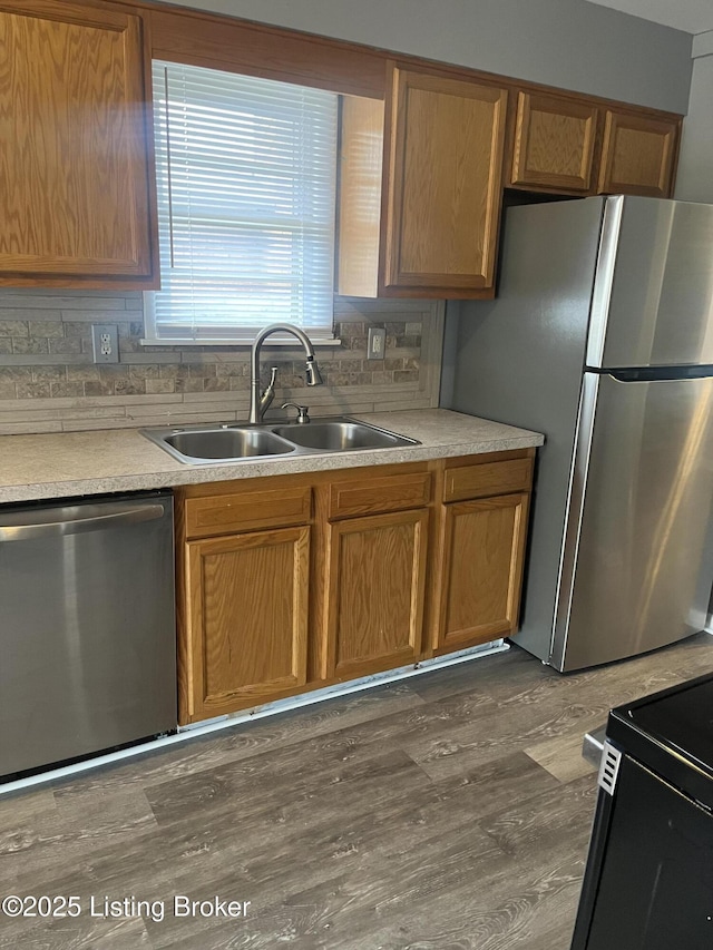 kitchen featuring decorative backsplash, stainless steel appliances, dark wood-type flooring, and a sink