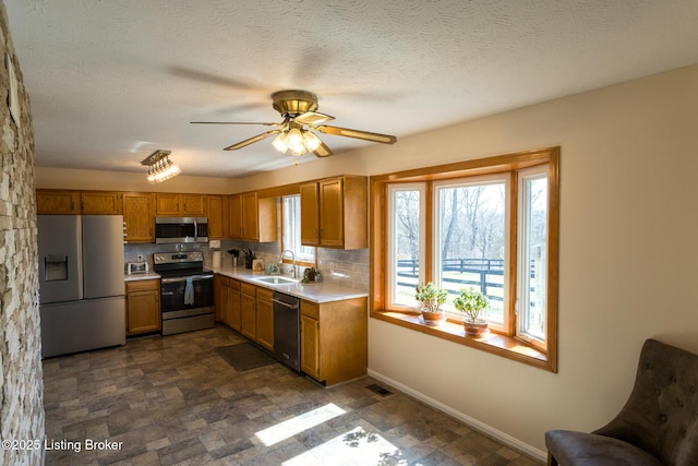 kitchen featuring visible vents, a sink, stainless steel appliances, light countertops, and tasteful backsplash