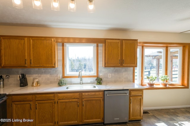 kitchen with dishwasher, decorative backsplash, light countertops, and a sink