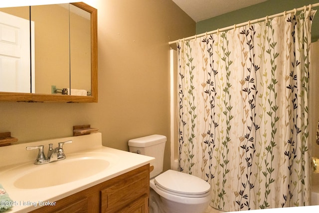 bathroom featuring curtained shower, toilet, and vanity