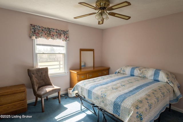 carpeted bedroom with ceiling fan and baseboards