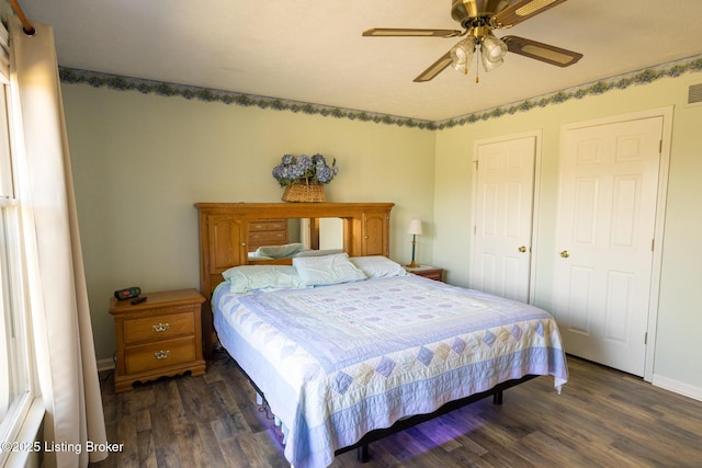 bedroom featuring ceiling fan, visible vents, baseboards, and wood finished floors