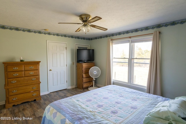 bedroom with a ceiling fan, baseboards, a textured ceiling, and dark wood-style flooring