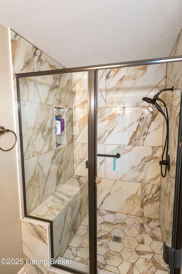 full bathroom with a textured ceiling and a shower stall