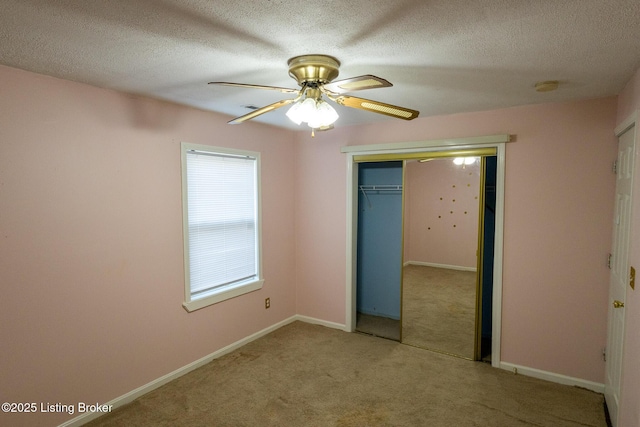 unfurnished bedroom with ceiling fan, baseboards, carpet floors, a closet, and a textured ceiling