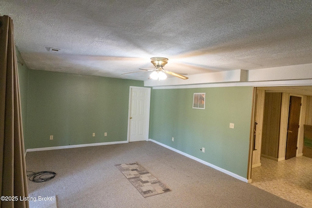 empty room with visible vents, baseboards, carpet flooring, a textured ceiling, and a ceiling fan