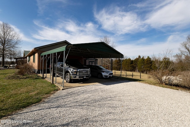 view of parking / parking lot featuring a carport and gravel driveway