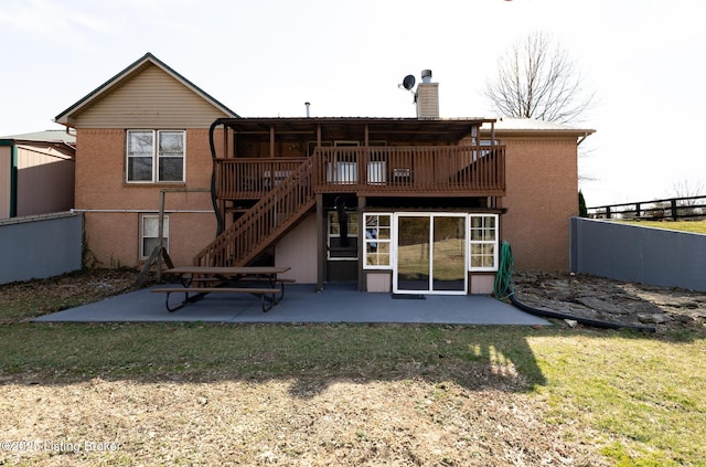 rear view of property featuring fence, brick siding, a chimney, and a patio area