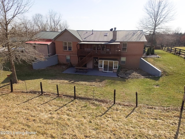 back of property with fence, a wooden deck, a yard, a patio area, and metal roof