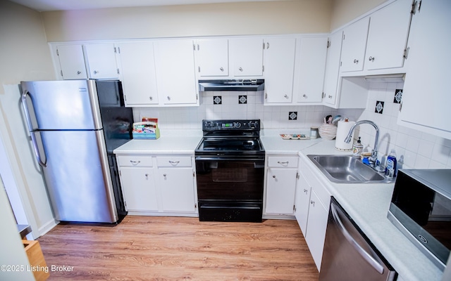 kitchen featuring light wood-style flooring, a sink, white cabinetry, stainless steel appliances, and extractor fan