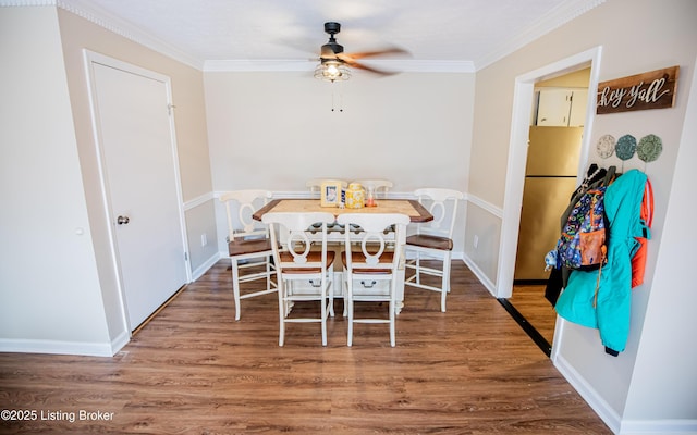 dining room with ornamental molding, baseboards, a ceiling fan, and wood finished floors