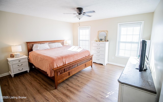 bedroom with baseboards, wood finished floors, and a ceiling fan