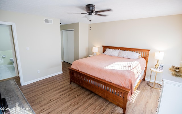 bedroom with visible vents, a closet, light wood finished floors, and baseboards