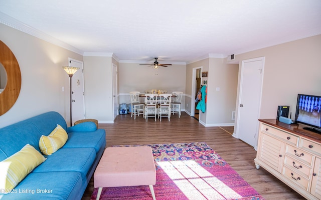 living area featuring visible vents, wood finished floors, and ornamental molding