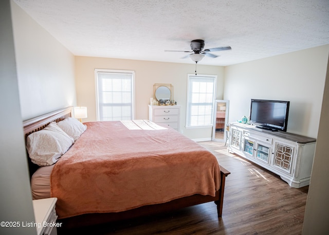 bedroom with ceiling fan, wood finished floors, and a textured ceiling