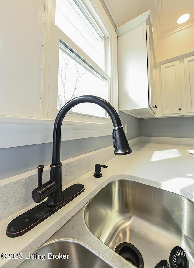 details featuring white cabinetry, light countertops, and a sink