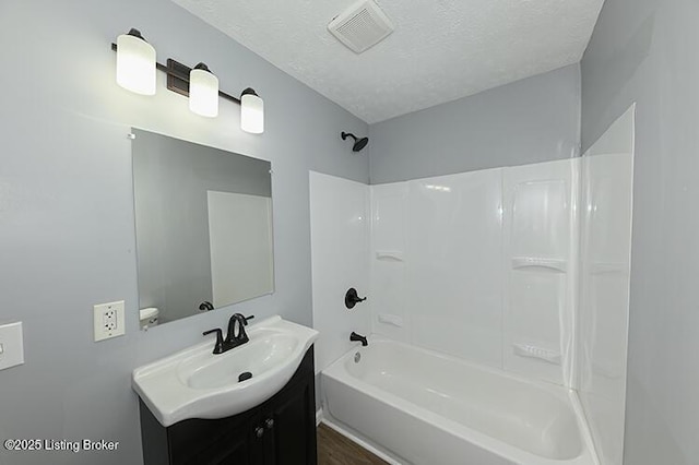 full bath with visible vents, a textured ceiling, vanity, and  shower combination