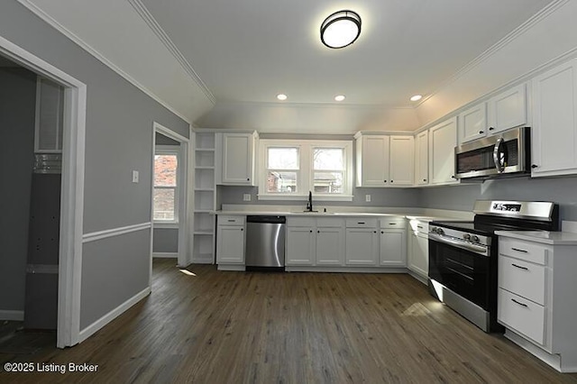 kitchen featuring dark wood finished floors, white cabinets, appliances with stainless steel finishes, and ornamental molding