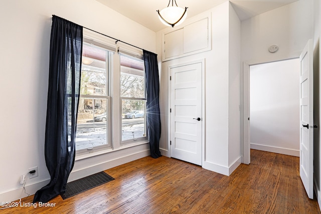 unfurnished bedroom featuring visible vents, baseboards, and wood finished floors