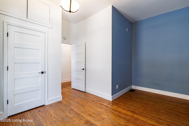 unfurnished bedroom featuring baseboards and wood finished floors