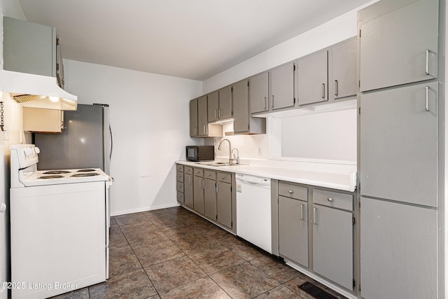 kitchen with visible vents, gray cabinets, a sink, white appliances, and light countertops