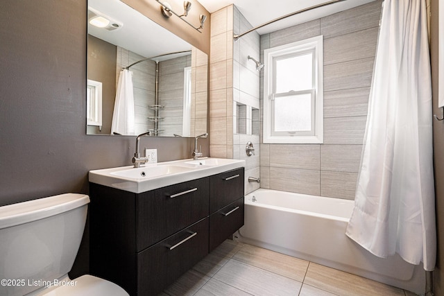 full bath with double vanity, toilet, shower / bath combo with shower curtain, and a sink