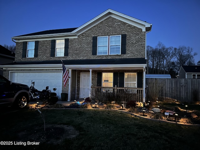 traditional-style home featuring brick siding, covered porch, a garage, and fence