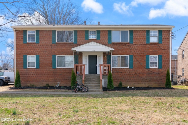 view of front of house with a front yard and brick siding