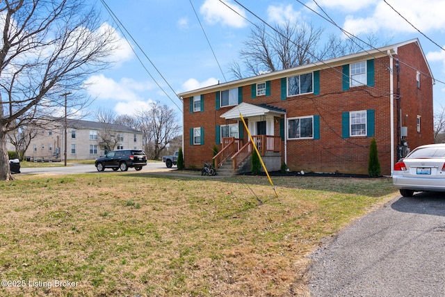 view of front of property with a front lawn and brick siding