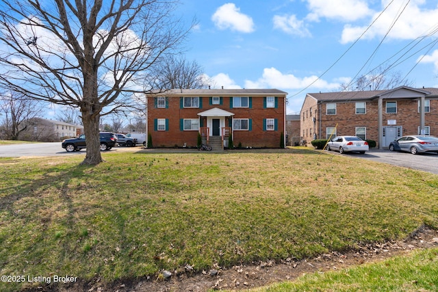 view of front of home featuring a front lawn and brick siding