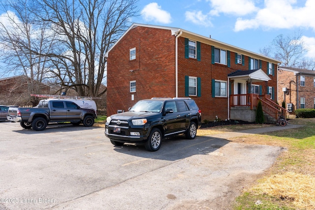 view of front of property featuring brick siding and uncovered parking