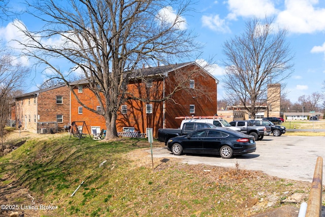 view of front of property featuring uncovered parking and a front lawn