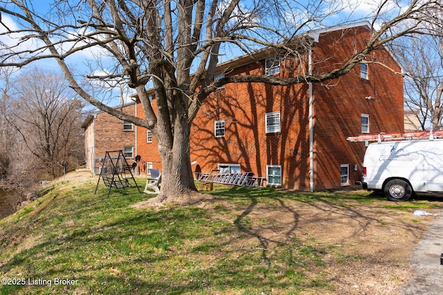 view of side of property with a lawn and brick siding