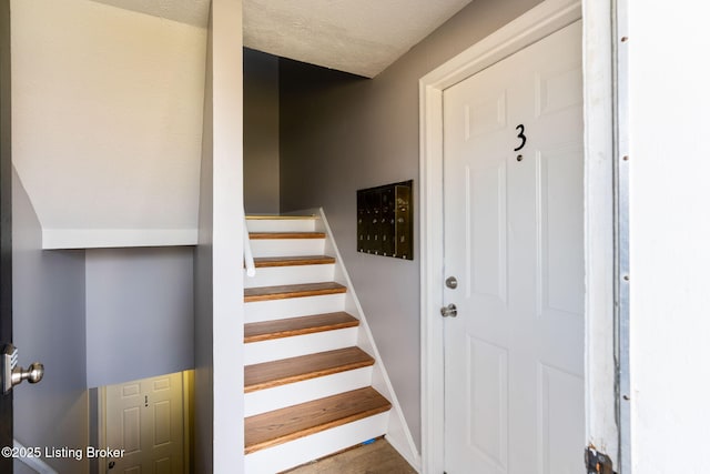 staircase with a textured ceiling