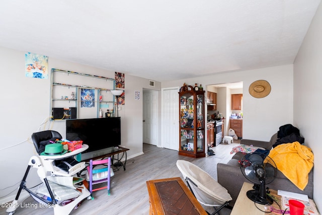 living area featuring light wood-style flooring and visible vents