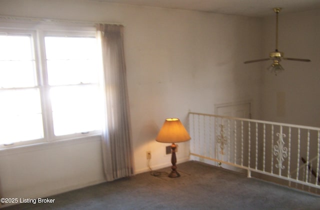 carpeted empty room with baseboards and ceiling fan