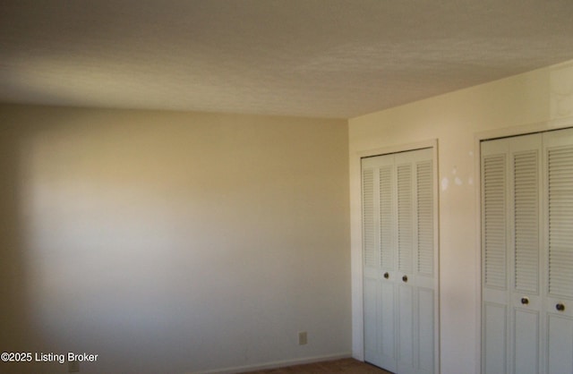 unfurnished bedroom featuring multiple closets