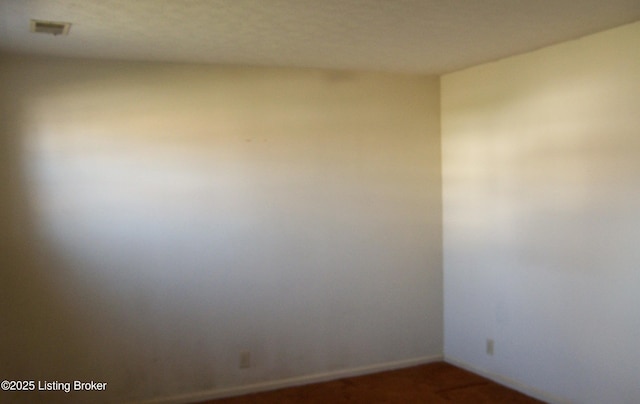 empty room featuring visible vents and dark carpet