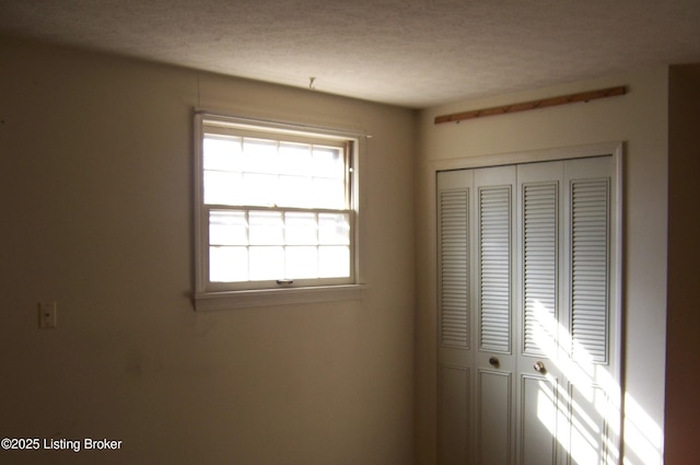 unfurnished bedroom with a closet and a textured ceiling