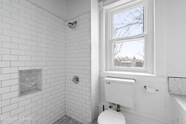 full bathroom with tiled shower and toilet