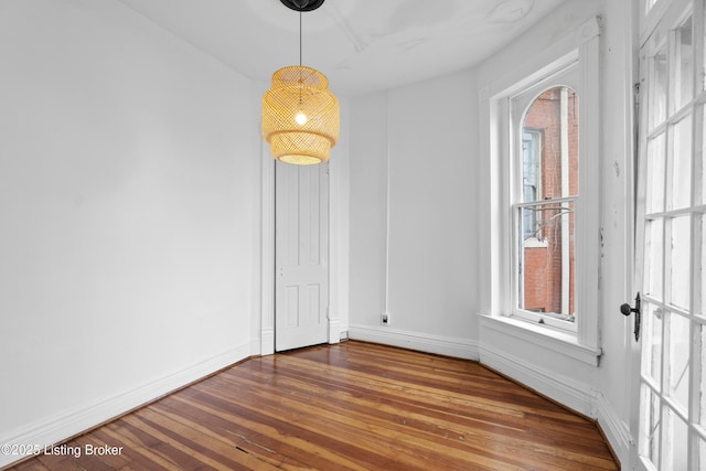 empty room with baseboards and hardwood / wood-style floors