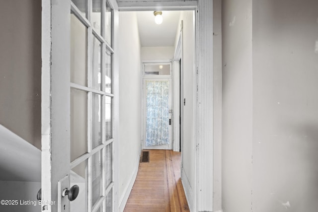 hallway with visible vents and wood finished floors