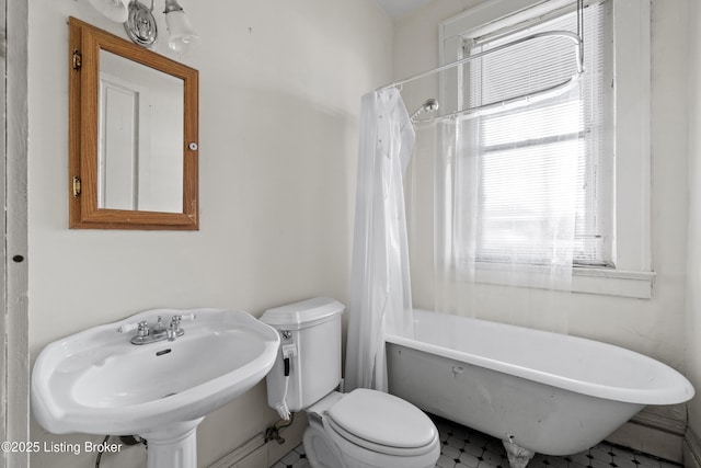 bathroom with curtained shower, a washtub, toilet, and a sink