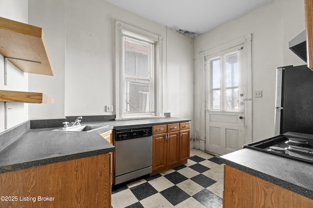 kitchen with a sink, open shelves, dark countertops, stainless steel appliances, and light floors